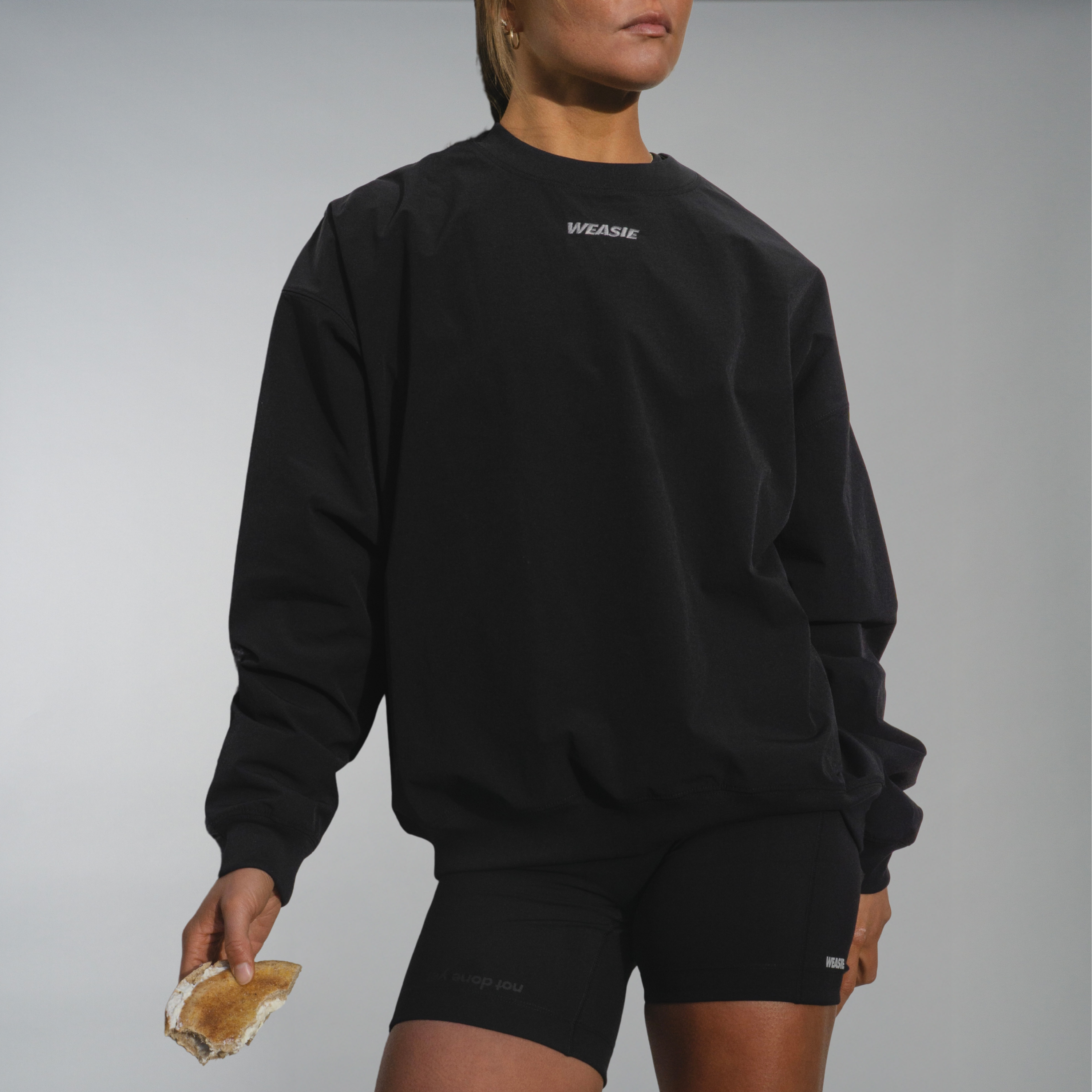 Women's black running recovery technical sweatshirt with embroidered logo, front view – WEASIE